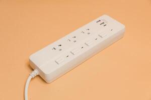Electrical plug in outlet socket at home, Electrical plug in outlet socket at home, Energy efficiency concept, Power strip with extension cord on beige background, top view. photo
