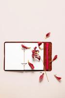 Open notebook with dried flower petals and pen. Creativity, writing or nostalgia concepts. photo