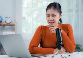 Content creator concept, woman talking into microphone on stand, lead on-line communication, discuss topic, looks at notebook screen, Engaged in streaming, Virtual meeting event, Podcast, Webinar. photo
