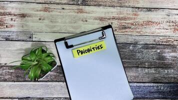 Concept of Priorities write on sticky notes isolated on Wooden Table. photo
