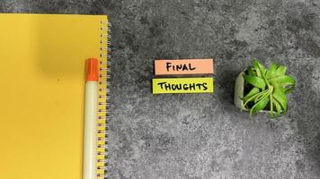 Concept of Final thoughts write on sticky notes isolated on Wooden Table. photo