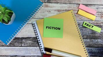 Concept of Fiction or Fact write on sticky notes isolated on Wooden Table. photo