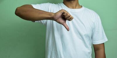 close up man, thumb down isolated on green background photo