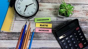 Concept of Conversion Rate Increase write on sticky notes isolated on Wooden Table. photo