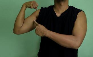I am strong and powerfull. Potrait of confident successful young man showing biceps photo