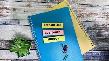 Concept of Personalize Customize Unique write on sticky notes isolated on Wooden Table. photo