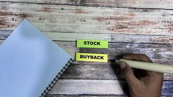 Concept of Stock Buyback write on sticky notes isolated on Wooden Table. photo