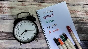 Concept of A Goal Without A Plan Is Just A Wish write on book isolated on Wooden Table. photo