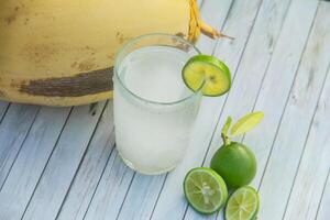 Fresh coconut water from yellow coconuts added with lime juice photo