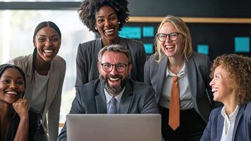 A group of people are smiling and laughing in front of a laptop video