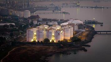 Banten, Indonesia - October 20th 2023 - Vopak Terminal Merak. Illuminated Oil Refinery Factory and Petroleum Tanks at Night photo