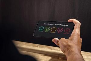Man holding a smartphone to give rating to service experience. Customer review satisfaction feedback concept. photo