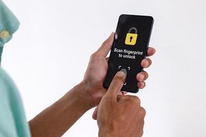 Man unlocks a smartphone by scanning fingerprint on screen. Security access with biometric identification concept. photo