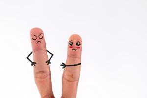 A pair of fingers in conflict, one with a sad face and the other with an angry face photo