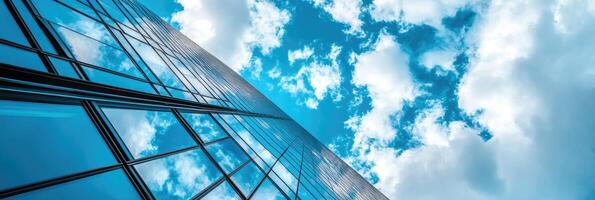 Low angle view of skyscraper with glass windows and blue sky background for business, trade and finance concept photo