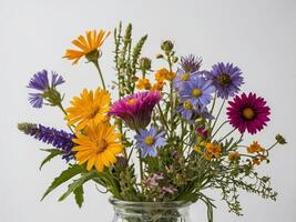 A vibrant bouquet of various colorful flowers arranged in a glass vase against a plain backdrop photo