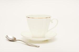 Tea pair on a white background. A cup and saucer with a spoon. photo