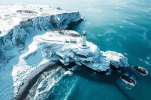 An aerial view captures a winter lighthouse towering over a rocky coastline, its presence a steadfast sentinel amidst a snow-dusted landscape. photo