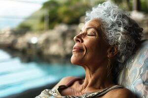 Senior woman with curly hair relaxing in a luxurious recovery facility, enjoying the serene and exotic views of the surrounding nature photo