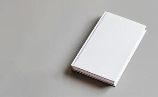 White blank book cover displayed on a solid grey background with copy space photo