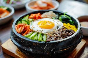 Bibimbap with vegetables, egg, and meat in a bowl photo