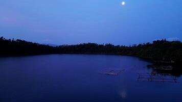 The moon over the lake before dawn video