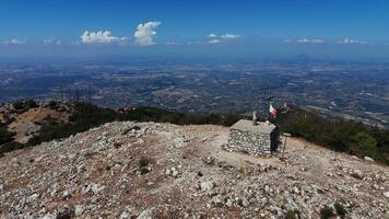 Majestic mountain view from the summit with a stone cross and Italian flag on a clear day video