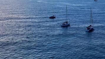 Aerial view of sailboats and dinghy navigating serene ocean waters video