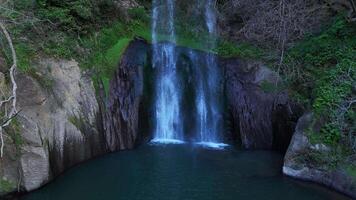 Majestic Waterfall Cascading Into Tranquil Pool Surrounded By Lush Greenery During Golden Hour video