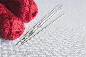 Skeins of wool yarn and needles for hand knitting on a grey background. Concept for handmade. photo