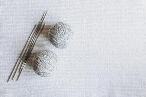 Balls of wool yarn and needles for hand knitting on a grey background. Concept for handmade. photo