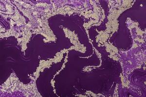 Gold sparkles wavy pattern on purple background. Acrylic Fluid Art. Abstract Art Deco background or texture photo