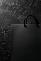 A black background with a subtle texture and the shadow of a shopping bag, leaving plenty of room for copy space photo