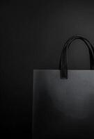 A black background with a subtle texture and the shadow of a shopping bag, leaving plenty of room for copy space photo