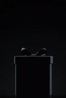 A black background with the silhouette of a gift box slightly off-center, ideal for promotional banners with copy space photo