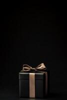 A black background with the silhouette of a gift box slightly off-center, ideal for promotional banners with copy space photo