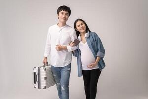 Portrait of Beautiful pregnant woman and husband traveling over white background studio, insurance and maternity concept photo
