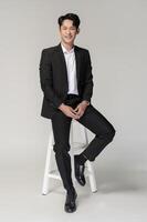 Portrait of Happy asian man wearing suit over white background photo
