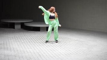 Enthusiastic woman in green outfit performing a dynamic dance routine with confidence and style video