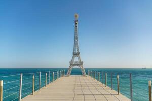 Large model of the Eiffel Tower on the beach. photo
