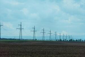 High voltage towers with sky background. Power line support with wires for electricity transmission. High voltage grid tower with wire cable at distribution station. Energy industry, energy saving photo