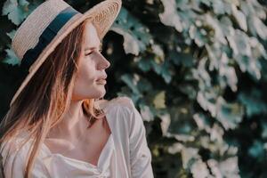 Woman with straw hat stands in front of vineyard. She is wearing a light dress and posing for a photo. Travel concept to different countries photo