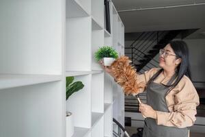 Smiling housekeeper dusting and arranging in office environment photo