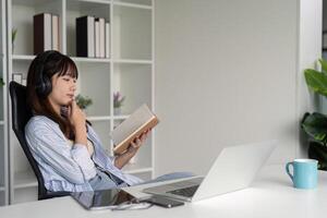 Focused Woman Combining Digital and Traditional Learning photo