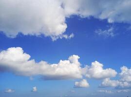 A blue sky with white clouds and a few people photo