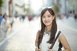 A glimpse into the life of a modern Asian woman, enjoying her journey through the urban landscape with confidence and style. photo