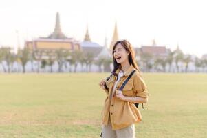 A Traveler Asian woman in her 30s exploring Wat Pra Kaew. From stunning architecture to friendly locals, she cherishes every moment, capturing it all in her heart and camera for years to come. photo