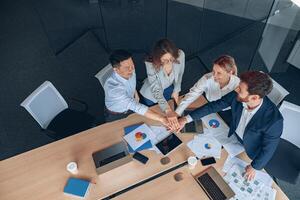 Happy successful multiracial business team showing unity with their hands photo