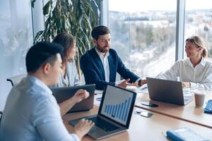 Creative business team working on project in modern office with panoramic view photo