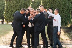 A group of men are standing in a circle, some of them are wearing suits photo